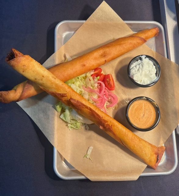 Chicken popper drumsticks served on a metal tray with two dipping sauces.