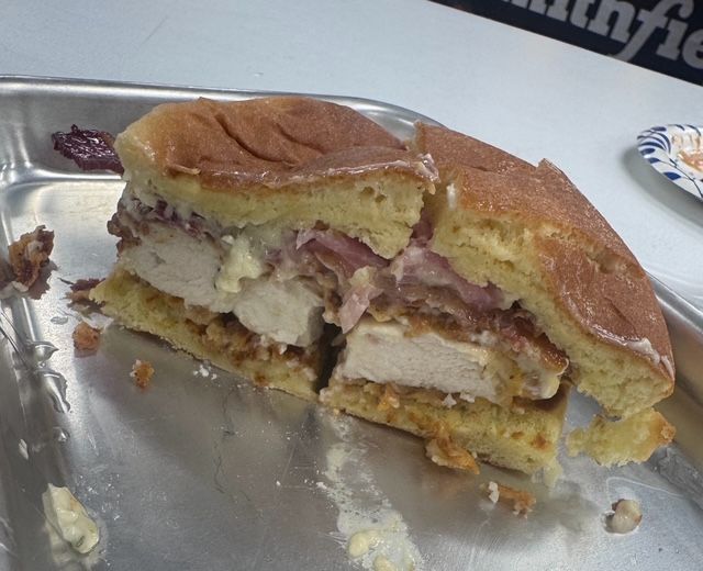 A chicken sandwich on a toasted bun, cut in half to show the filling.
