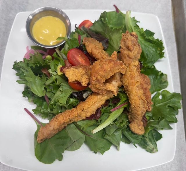 Iowa chop salad with breaded chicken strips over mixed greens and tomatoes.